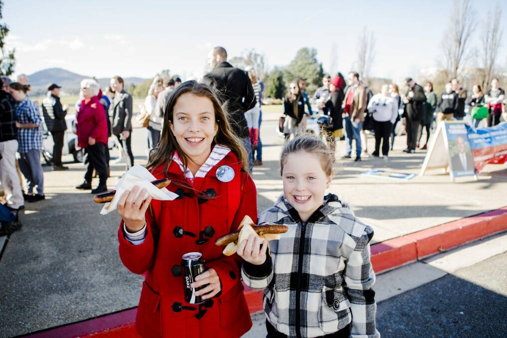 Tabatha Fachin 11, and her sister Chiara 9, of Brisbane enjoying the sausage sizzle at Old Parliament House on election day. Photo: Jamila Toderas
