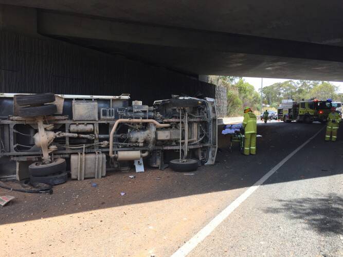 A truck rolled over on Parkes Way under the Caswell Drive underpass on Friday afternoon. Photo: Emergency Services Agency