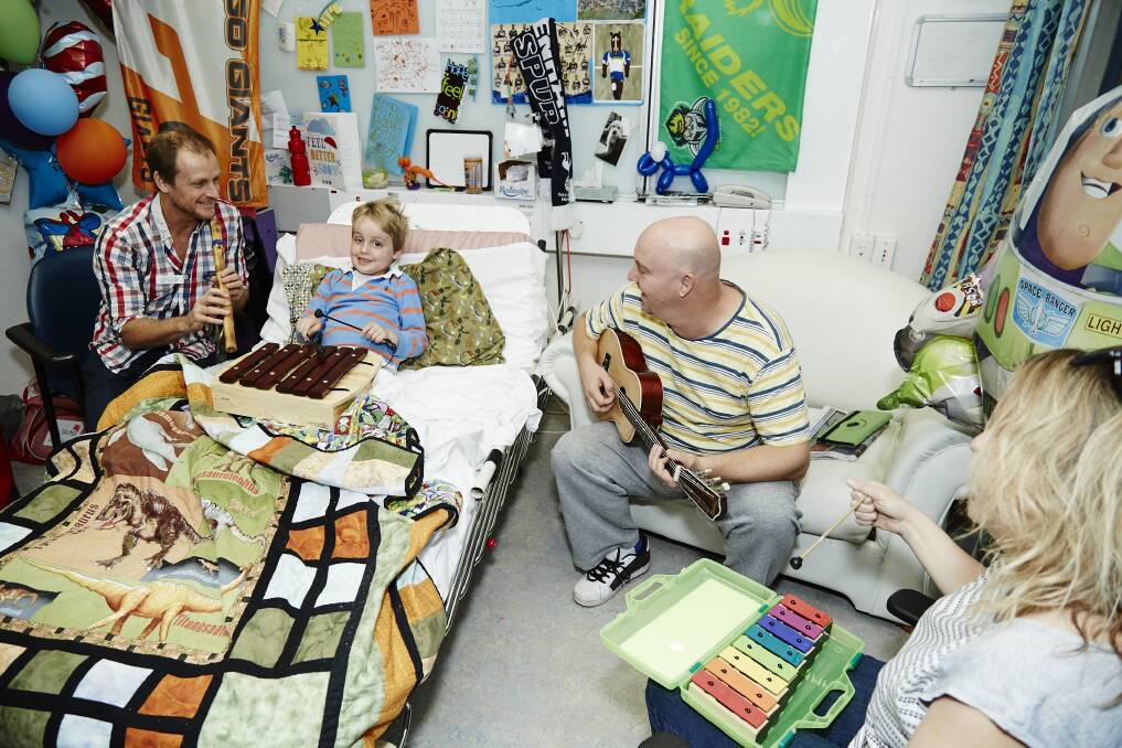 Jack Woodhams plays the xylophone with music therapist Matt Ralph during his stint in hospital. Photo: Supplied