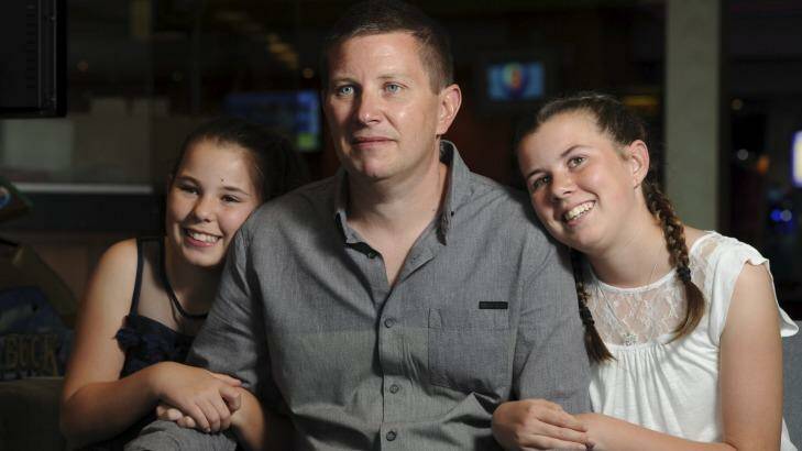 Recovering from his injuries, Andrew McInnes attends the fund raising benefit with daughters Taya, 12, left, and Courtney, 13. Photo: Graham Tidy