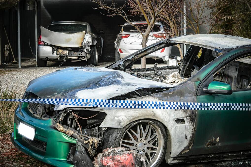 Police examine a property in Kambah after shots were fired and vehicles set alight on Friday morning in what police are describing as the latest incident in an ongoing bikie feud. Photo: Sitthixay Ditthavong