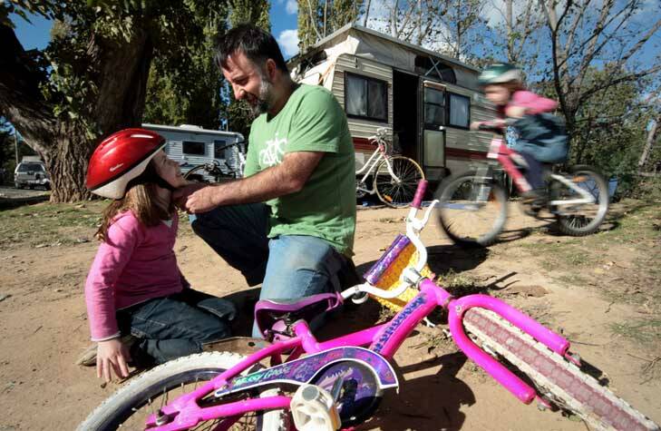 Back to basics ... Chris Jordan, of Mount Gambier, helps daughter Elise, 6, while Erin, 8, rides her bike at the Queanbeyan Riverside Tourist Park. Photo: Jeffrey Chan