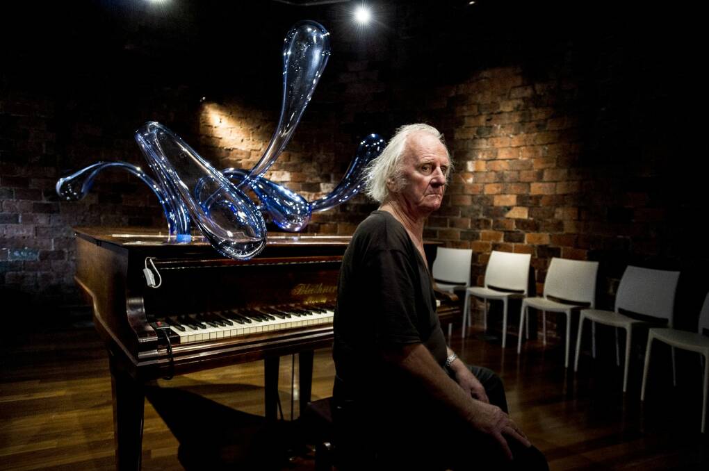 Artist Ken Unsworth with his latest work, Smokestack Piano, which involves forms made of blown glass. Photo: Jay Cronan