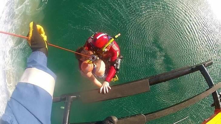 The 13-year-old surfer is winched to safety at Bar Beach in Narooma on Sunday. Photo: Supplied