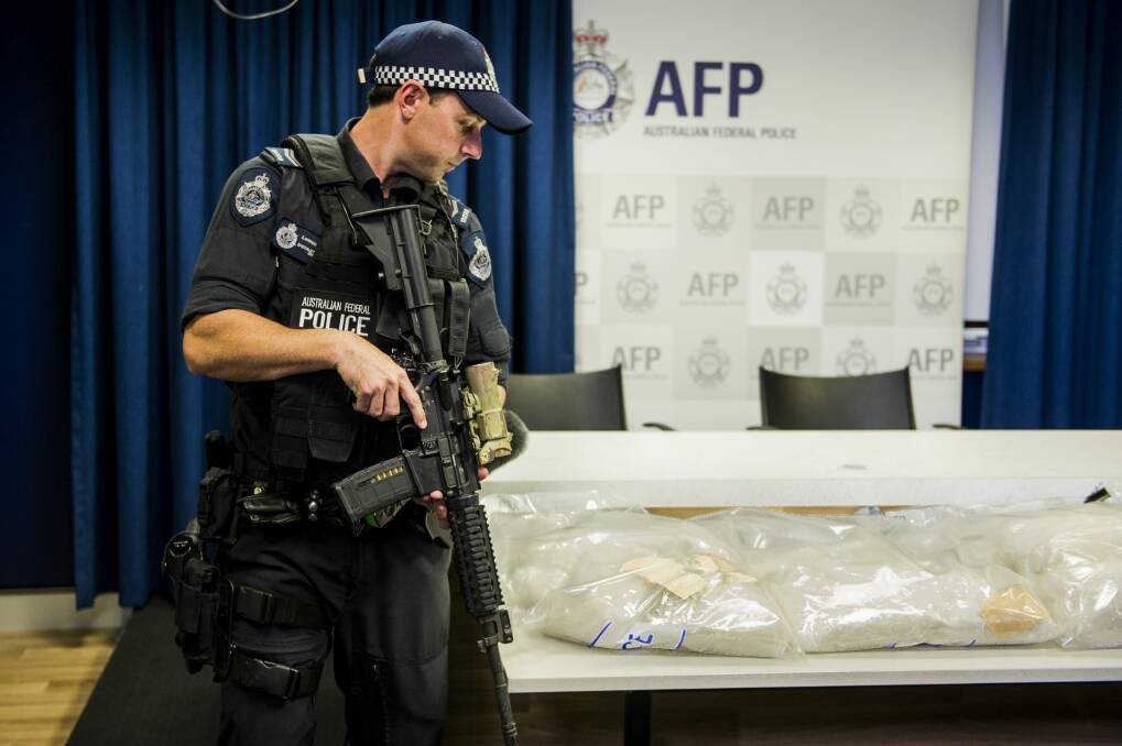 An armed police officer stands guard over one of the ACT's largest drug seizures of methamphetamine. Photo: Jay Cronan