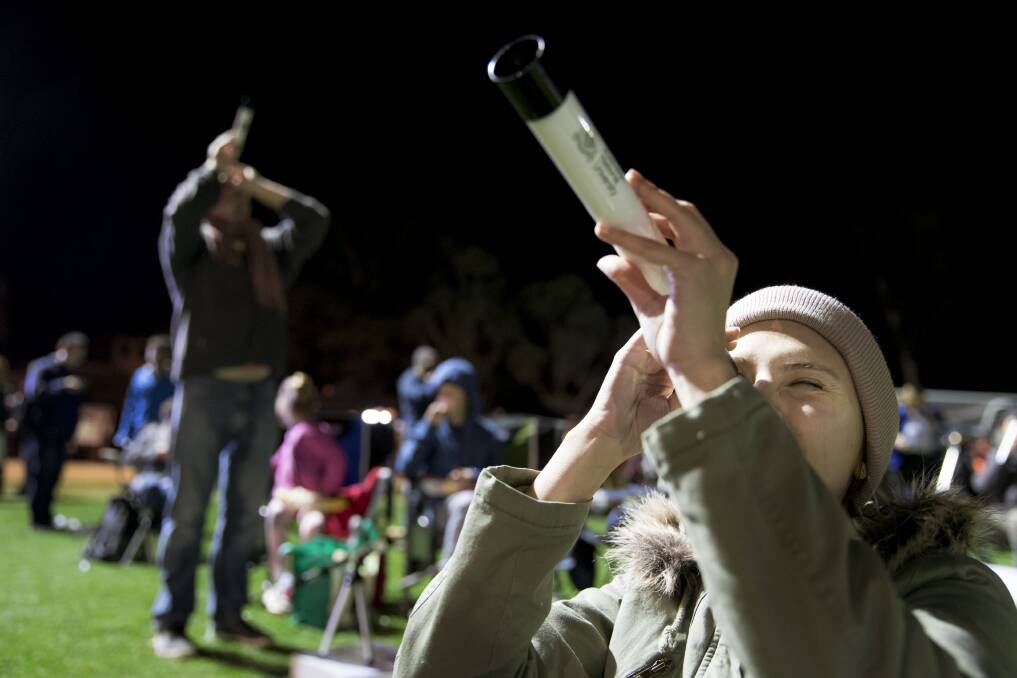 Australian National University microbiology student Mahboobeh Behruznia scans the sky during an attempt to break the Guinness World Record for the most people simultaneously stargazing at multiple venues. Photo: Sitthixay Ditthavong