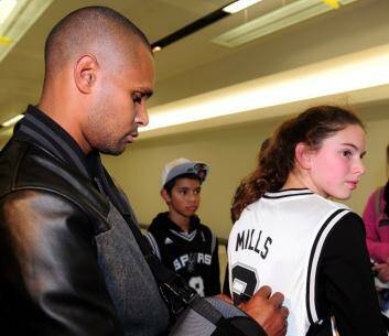 Patty Mills signs an autograph for Alyssa Seden,12, of Stirling, at Canberra Airport. Photo: Melissa Adams