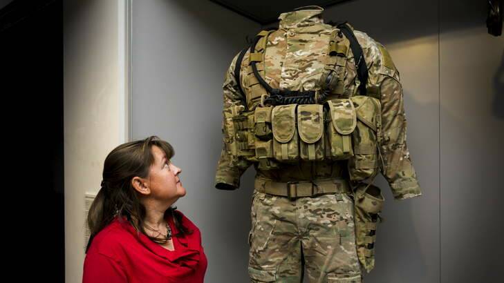 Larger than life... Head textiles conservator, Sarah Clayton inspects the combat uniform of Victoria Cross recipient Ben Roberts-Smith. Photo: Rohan Thomson