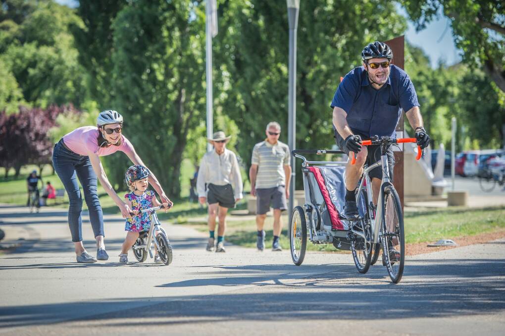 Pedal Power communications manager Anne Treasure with husband Glen Fuller and daughter Aurora enjoy cycling together around Lake Burley Griffin. Photo: Karleen Minney