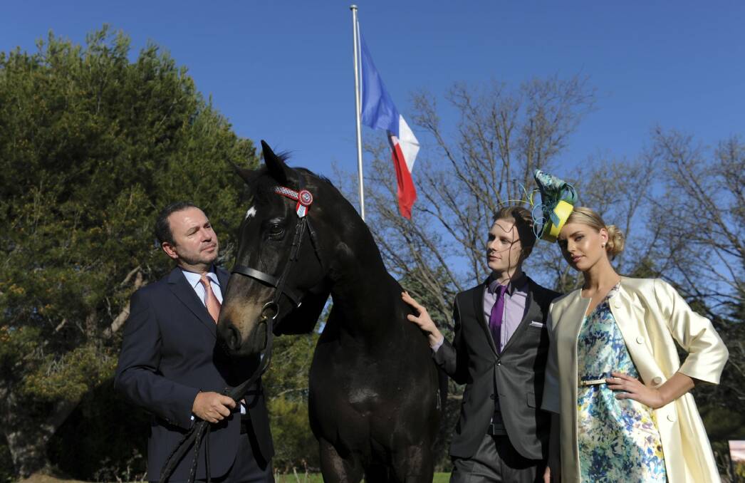French Ambassador Christophe LeCourtier, left, holding "Casts a Shadow" with models Denzel Bruhn and Becky Patterson on the lawns of the French Embassy ahead of the Melbourne Cup preview event later this month. Photo: Graham Tidy