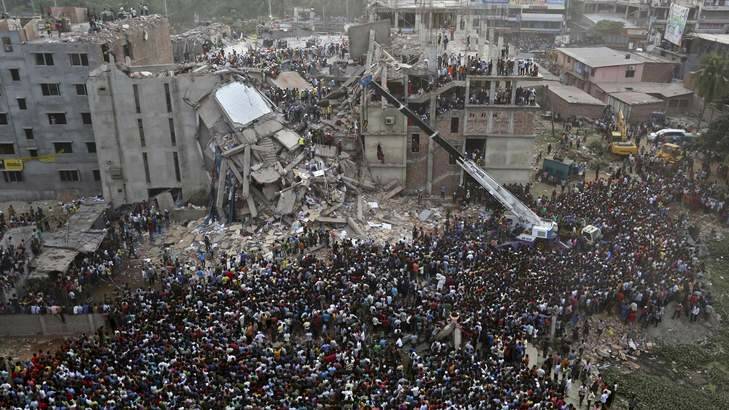 Desperate wait: Bangladeshis watch the rescue operations at the doomed factory. Photo: AP