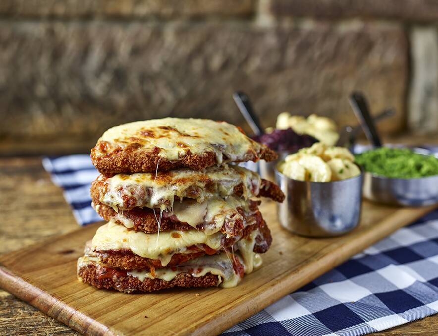Meet the Schnitzelmeister. It’s a six-stack, chicken schnitzel tower topped with Napoli sauce, ham and cheese and served with four side dishes.
 Photo: Supplied 