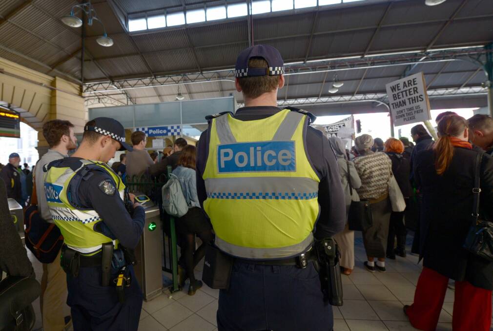 Police watch as protesters rally inside Flinders Street Station on Friday against    Australian Border Force officers taking part in Operation Fortitude. Photo: AAP