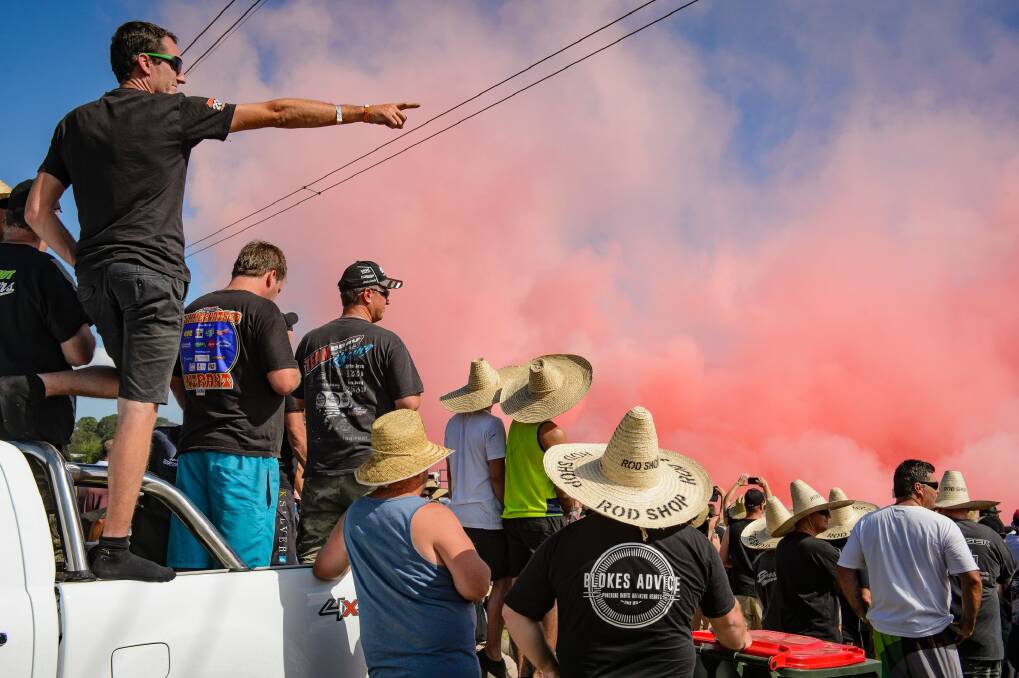 Spectators watch a burnout competition at Summernats in 2018. Some are wearing appropriate broad brimmed hats. Photo: Sitthixay Ditthavong