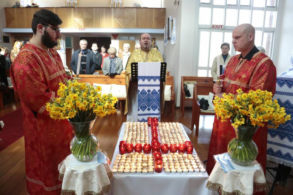From left, Nicholas Solomko, Father Michael Solomko and Arthur Levics during the memorial service at the Ukrainian Orthodox Church in Turner for the victims of the Malaysia Airlines disaster. Photo: Jeffrey Chan