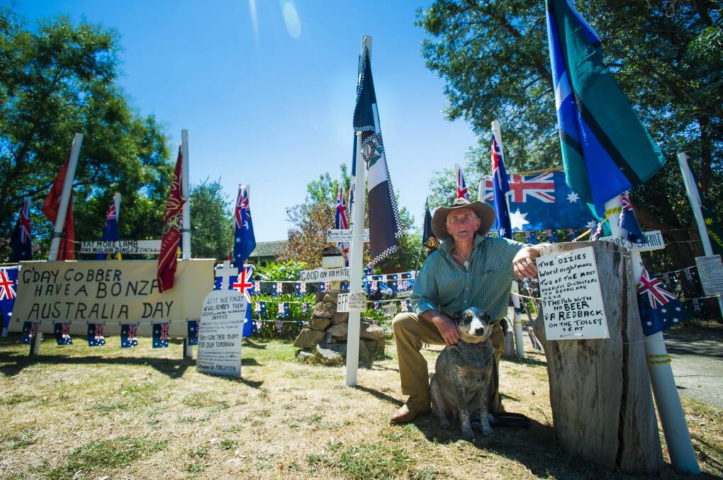 Dave 'Spurs' Goodall, pictured with his dog RM, decorated his front yard with flags for an Australia Day party celebration. Photo: Elesa Kurtz