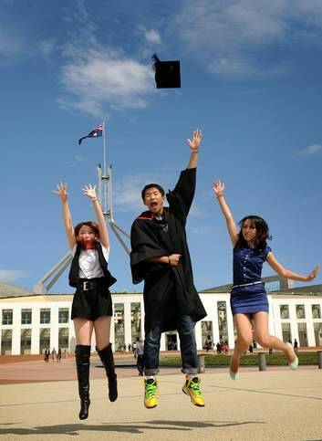 SCHOOL'S OUT: University of Canberra graduates Xiyuan Rong, Zhaochen Di, Ziqian Yu celebrate their efforts outside Parliament House. Photo: Colleen Petch