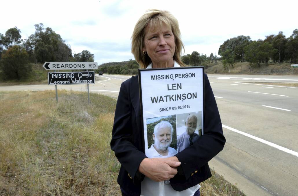 Kate O'Brien, the youngest sister of Leonard Watkinson, with the missing person poster and sign on the Hume Highway. Photo: Graham Tidy