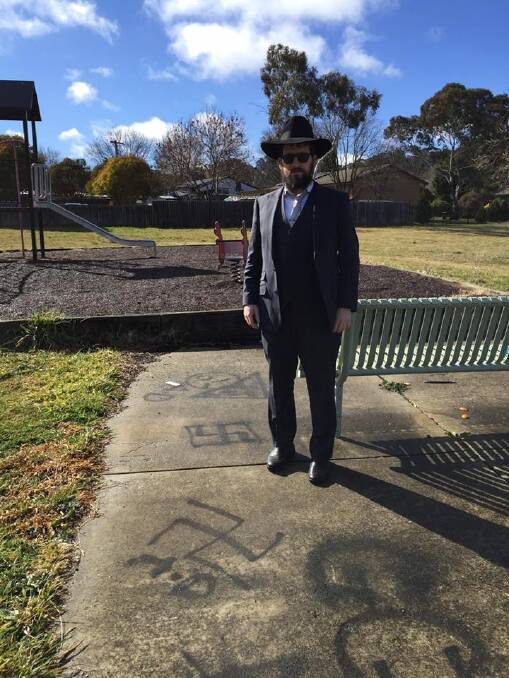 Rabbi Shmueli Feldman stands behind the graffiti near his synagogue in northern Canberra. Photo: Supplied