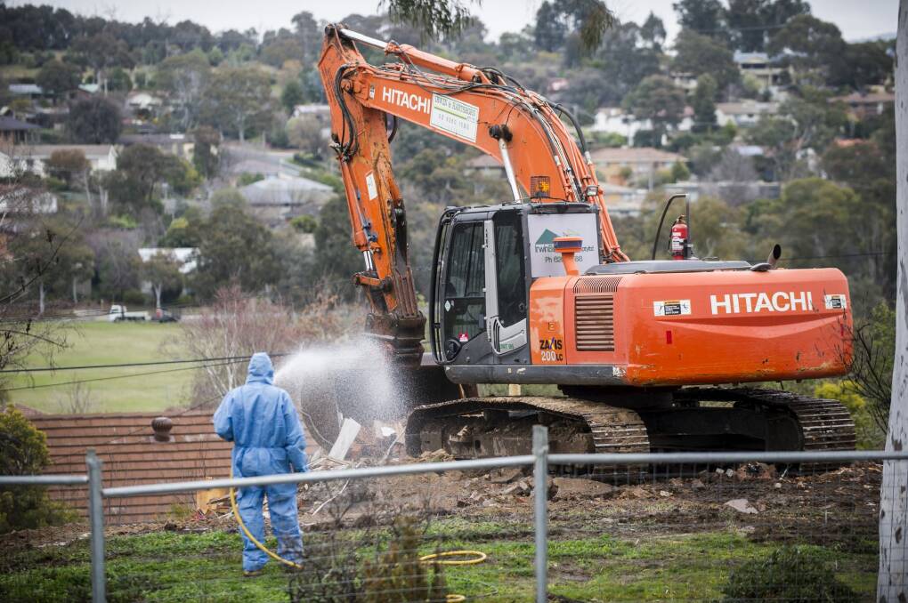 Workers demolish a Mr Fluffy home. Photo: Rohan Thomson