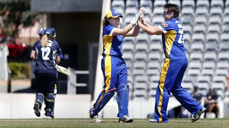 Victoria's Brianna Binch walks off the field as ACT Meteors wicket keeper Laura Wright and bowler Kris Britt celebrate her dismissal. Photo: Jeffrey Chan