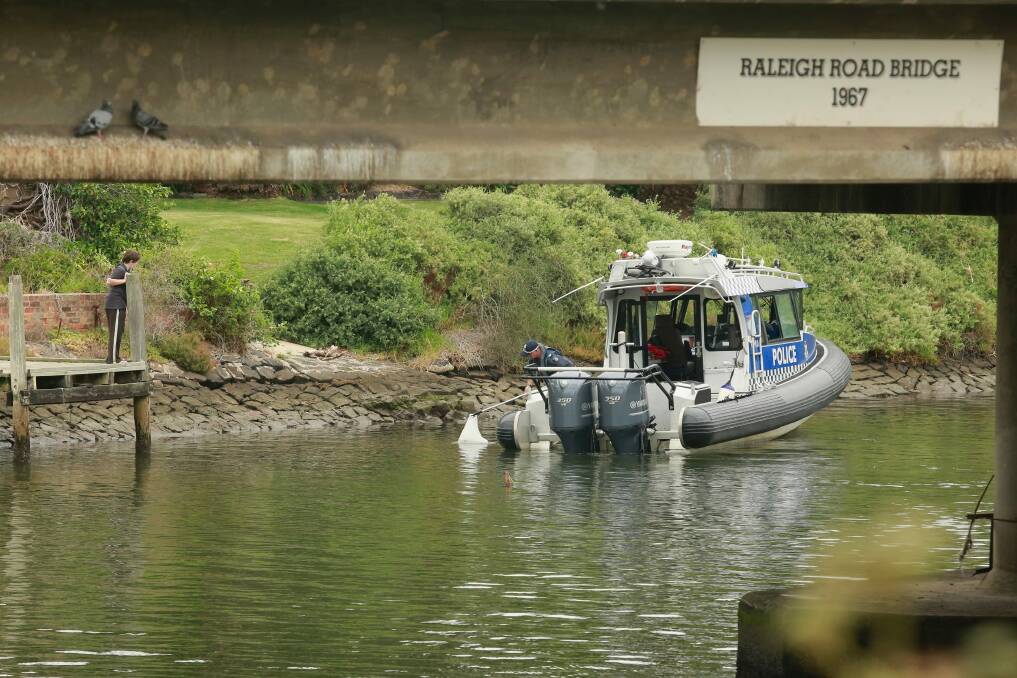 A child looks on as police retrieve another suspicious object from the river in February. Photo: Chris Hopkins