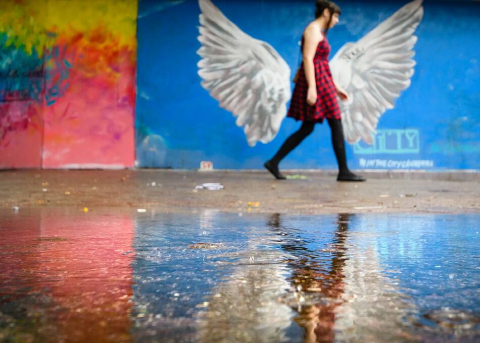 A pedestrian avoids a large puddle in Garema Place on Saturday afternoon.  Photo: Sitthixay Ditthavong