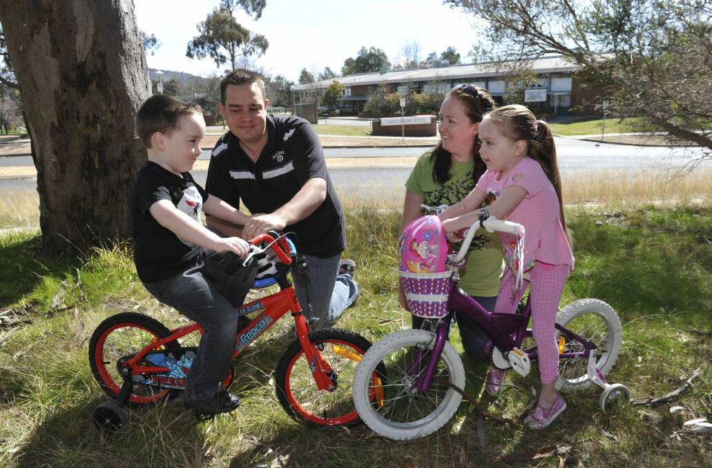 Farrer residents Ashley and Amey Bencke with
their children Joseph, 4, and Kayley, 6, near their local school, Farrer Primary. Photo: Graham Tidy