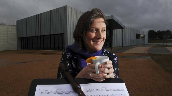 Musican and recorder specialist, Claire Taylor, 24 of Hawker, warms up with a mug of mulled wine as storm clouds gather over the Belconnen Arts Centre. Photo: Graham Tidy