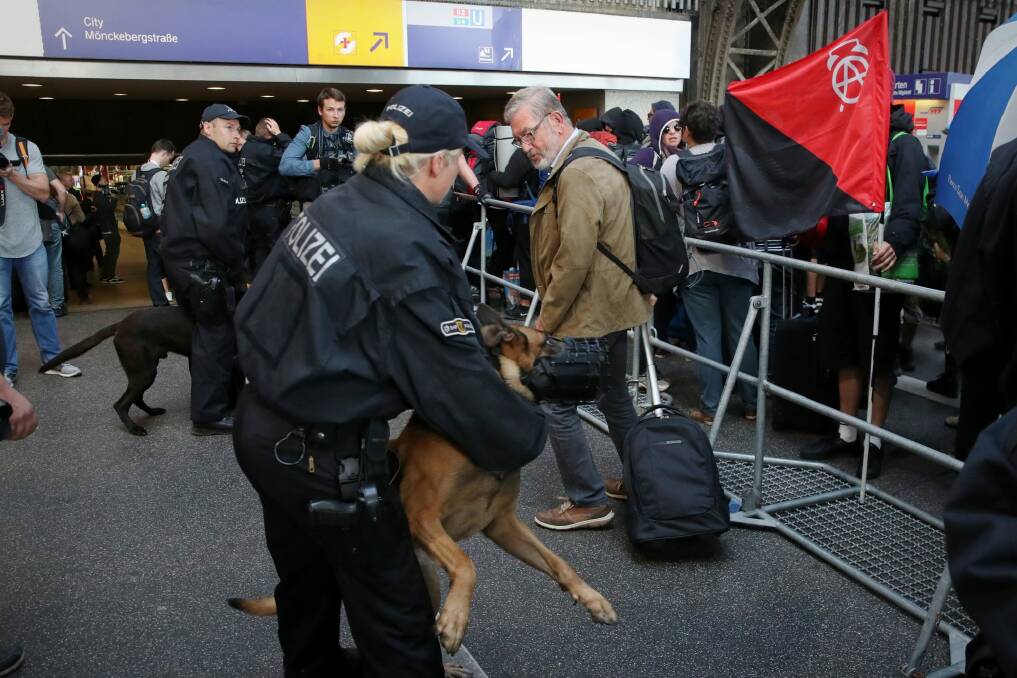 Police monitor protesters who have arrived in Hamburg to rally against the G20. Photo: Andrew Meares