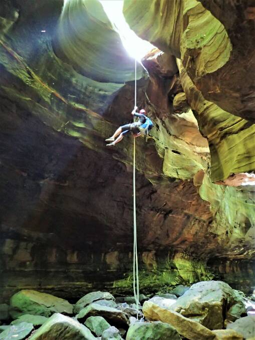 Abseiler Tom Walker in search of glow worms. Photo: Peter Blunt