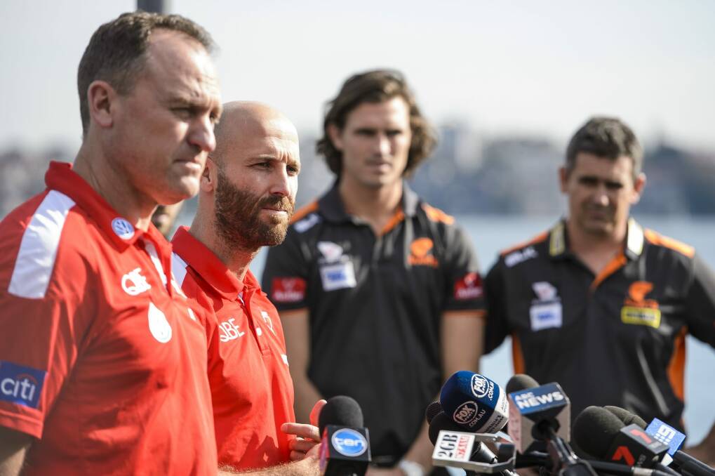 "Once the ball bounces any of those talks fall out the window straight away. Both sides are really evenly matched": John Longmire, with Swans' skipper Jarrad McVeigh, and GWS counterparts Callan Ward and Leon Cameron.  Photo: AFL Media