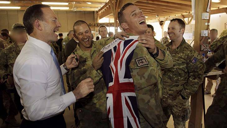 Prime Minister Tony Abbott, pictured with troops during a recent visit to Tarin Kowt, has announced the last Australian soldiers left Oruzgan on Sunday. Photo: Andrew Meares