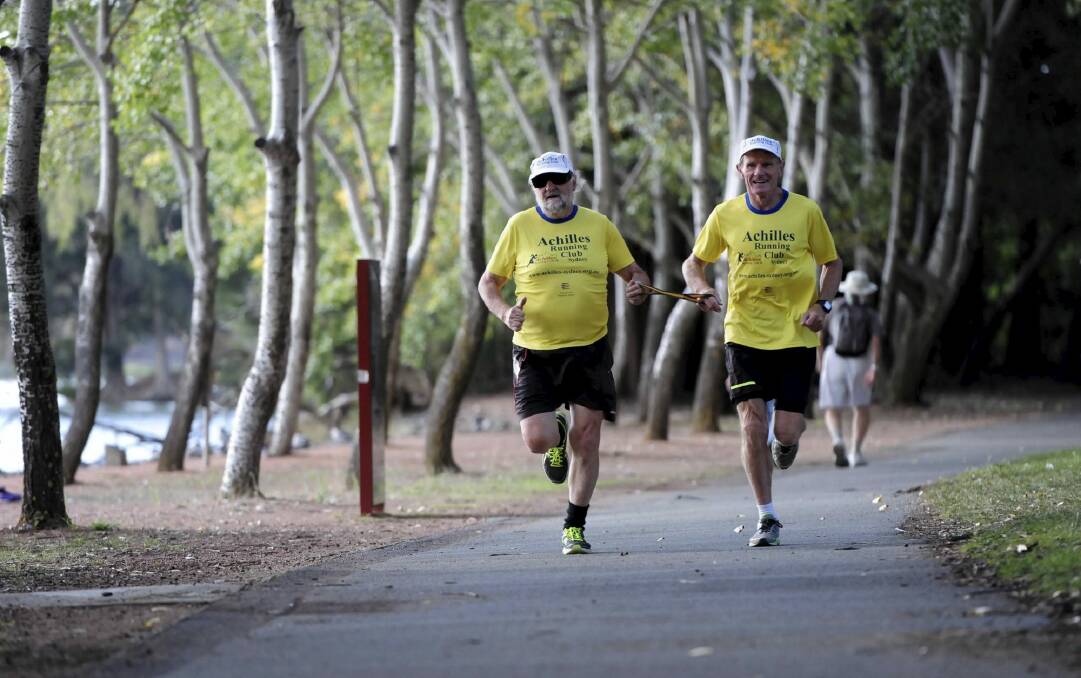 Local marathon runner, Peter Ralston of the Canberra chapter of Achilles International Australia, right, leading blind runner, Peter Granleese, who will be competing during the Canberra Running Festival. Photo: Graham Tidy
