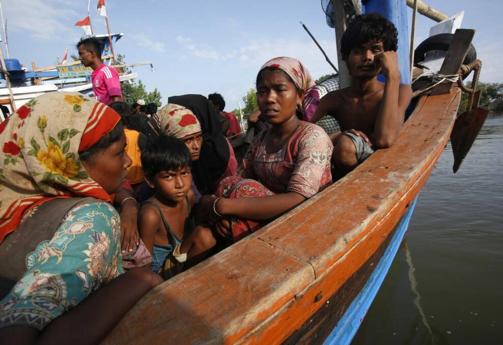 Rescued migrants sit on an Acehnese fishing boat upon arrival in Indonesia. Photo: AP