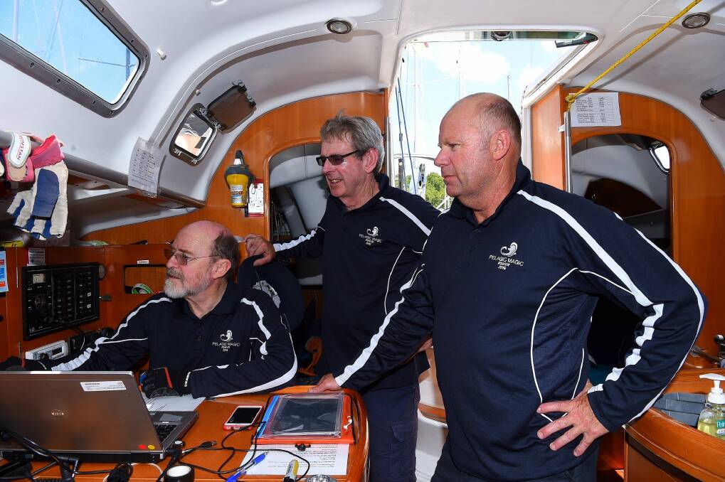 Pelagic Magic crew members former AFP Commissioner Shane Connelly (right) with the navigator Paul Jones (left) and skipper Simon Dunlop (2nd from left) preparing for the Sydney to Hobart race. Photo: Kate Geraghty