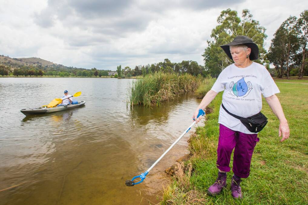 Tuggeranong Lake Carers Group members Lesley McGrane and Bill Perry remove rubbish from the lake. Photo: Matt Bedford