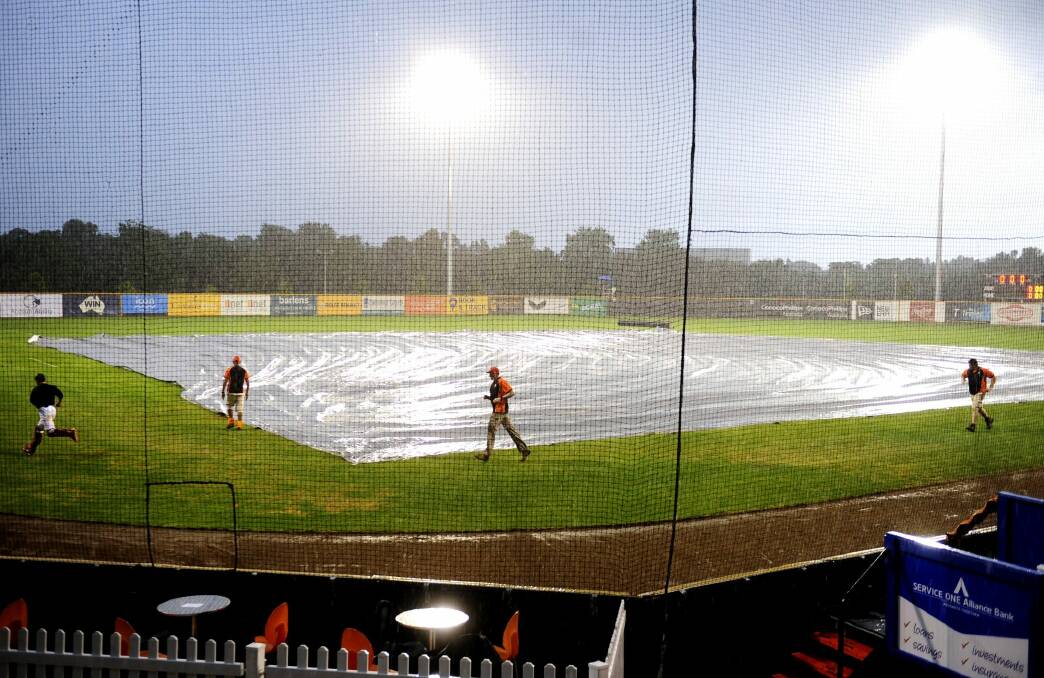 The covers were out at Narrabundah Ballpark on Thursday night as the deluge washed out the match between the Canberra Cavalry and the Sydney Blue Sox. Photo: Melissa Adams  