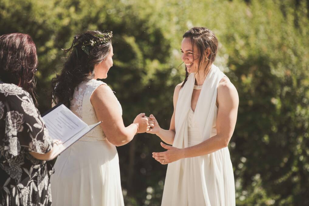 Sally and Kara Bromley seal their marriage with a pinkie promise. Photo: Jamila Toderas