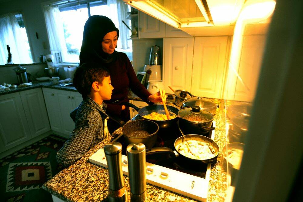 The Erdogan family of Farrer share an Iftar meal - the evening meal when Muslims break their fast at sunset during Ramadan. Handan Erdogan and Nurullah, 9, prepare food. Photo: Karleen Minney
