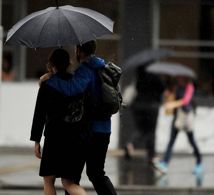 Canberra's big wet ... pedestrians in Civic use umbrellas to try and stay dry. Photo: Stuart Walmsley