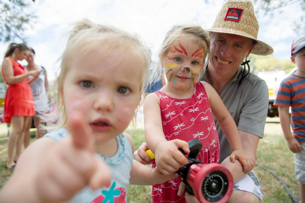 Emma, 2, Heidi, 4, and Peter Young taking part in the fire crew demonstrations at the event. Photo: Jay Cronan