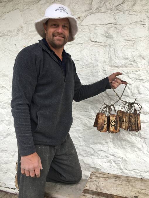 Andy Van der Wacht with the historic tags unearthed in the foundations of the Cobb &amp; Co coach stables at The Sir George in Jugiong. Photo: Tim the Yowie Man