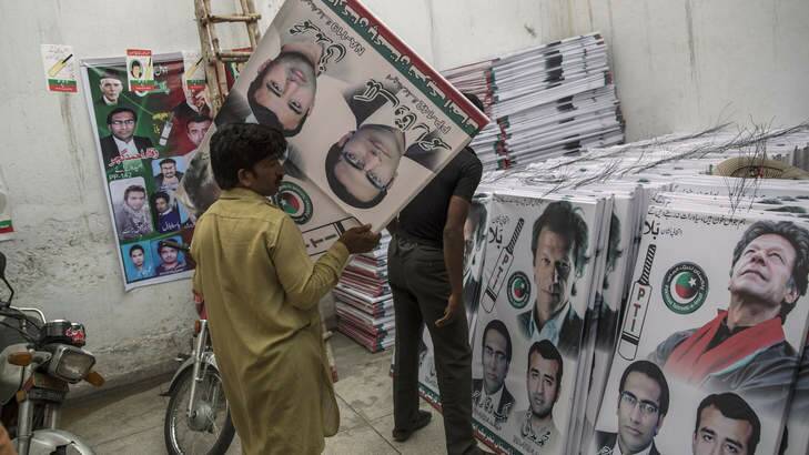 Party volunteers prepare  campaign posters of Imran Khan in Lahore ahead of Saturday's election. Photo: Getty Images