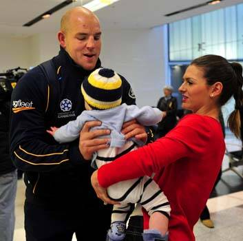 Brumbies hooker Stephen Moore with his son Theodore and wife Courtney at the Canberra airport on his return from South Africa. Photo: Melissa Adams