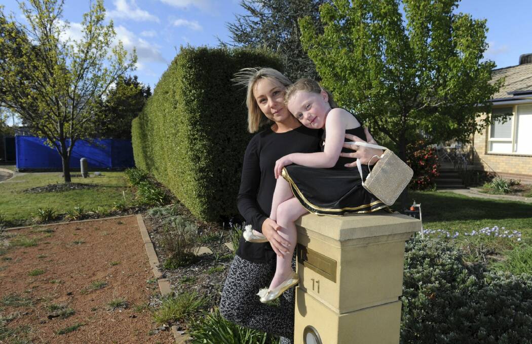 Torrens residents Sarah Tilse and her daughter Mia outside their home. They are just two of the neighbours concerned they were not informed about the botched demolition of a Mr Fluffy house.  Photo: Graham Tidy