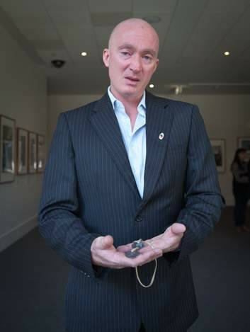 Donator Paul Liversidge, great-grandson of Mary Hutchins holding dog tags belonging to his family. Photo: Katherine Griffiths
