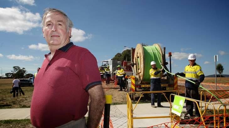 Ewan Brown, president of the Gungahlin Community Council, in front of the Fibre Optic Cable being layed in Gungahlin. Photo: Alex Ellinghausen