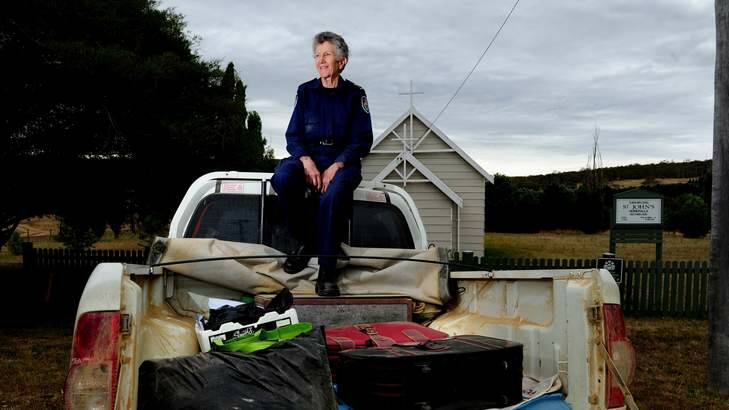 RFS and Ambulance Chaplain Jenni Roberts sits on the back of her ute with the items that she had decided to take with her if her home was destroyed in the fires. Photo: Melissa Adams