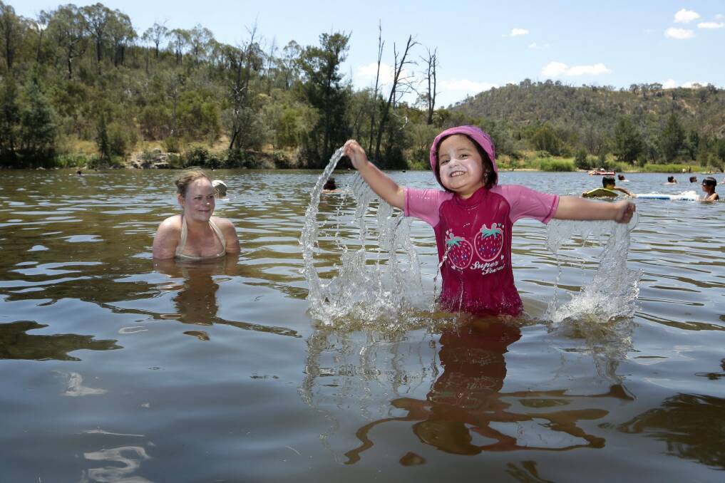 Tristan Viscarra Rossel with daughter Elena Viscarra Rossel, 3, cool off in the Murrumbidgee River at Casuarina Sands. Photo: Jeffrey Chan 